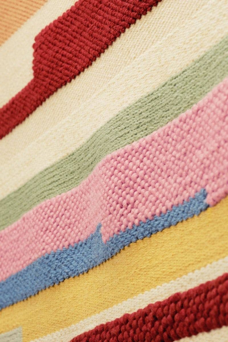 Close up of the BRÖNDEN rug, highlighting the different weaving techniques and contrasting colours.